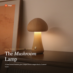 Wooden mushroom LED night light in natural beech finish glowing warmly on a bedroom nightstand